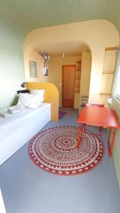 um quarto com uma cama e uma mesa vermelha em Private small studio in Costa de Caparica em Costa da Caparica