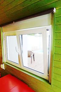 ventana en una habitación con sofá rojo y silla en Private small studio in Costa de Caparica, en Costa da Caparica