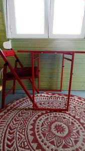 a red table sitting on top of a rug in a room at Private small studio in Costa de Caparica in Costa da Caparica