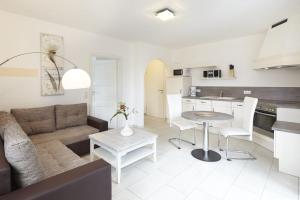 a living room and kitchen with a couch and a table at Sea Captain - Ferienwohnungen in Büsum