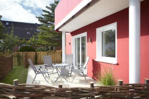 a patio with chairs and a table next to a building at Sea Captain - Ferienwohnungen in Büsum