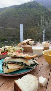 a table topped with plates of food with bread and cheese at Te baca Qerim in Lekbibaj