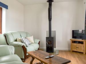 a living room with a couch and a wood stove at Roe Cottage - Uk33490 in Hadleigh