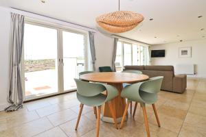 a dining room with a table and chairs and a couch at APARTMENT BY THE BEACH The Foxcove in St Merryn