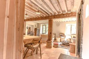 a dining room with a table and a living room at Charme Zen Ecrin de verdure Fraîcheur Spa en juillet in Pezens