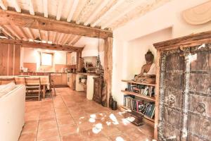 a large kitchen and dining room with a person sitting on a book shelf at Charme Zen Ecrin de verdure Fraîcheur Spa en juillet in Pezens