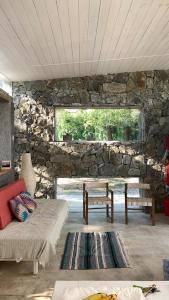 sala de estar con pared de piedra y sofá en Jauja, en San Javier
