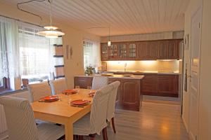 Villa Sankt Olof في Sankt Olof: مطبخ وغرفة طعام مع طاولة وكراسي خشبية
