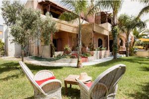 due sedie e un tavolo di fronte a una casa di Hajrienne guest house a Tangeri