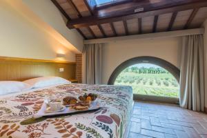 una camera d'albergo con un letto e un vassoio di cibo sopra di Collina dei Poeti a SantʼArcangelo di Romagna