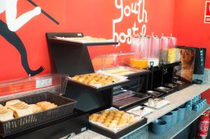 a counter with trays of pastries and other food at Quart Youth Hostel & Apartments in Valencia