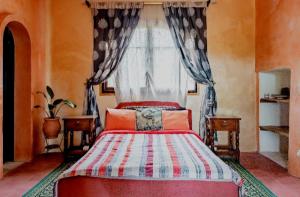 una camera da letto con un letto rosso e una finestra di Hajrienne guest house a Tangeri