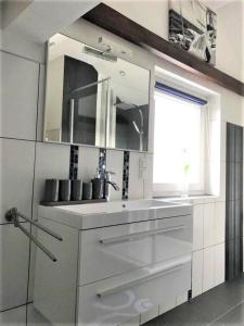 een witte keuken met een wastafel en een spiegel bij Frau Holle in Wolfhagen