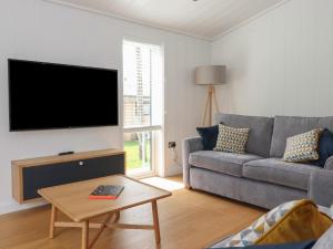 un soggiorno con divano e TV a schermo piatto di The Brambles a Ulverston