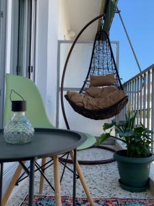 a porch with a swing and a table and a chair at URBAN MAISON in Larisa