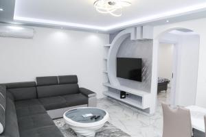 ein Wohnzimmer mit einem Sofa und einem TV in der Unterkunft Apartman Viktor in Igalo