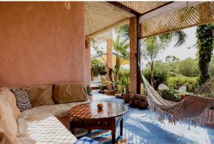 ein Wohnzimmer mit einem Sofa und einer Hängematte auf einer Terrasse in der Unterkunft Hajrienne guest house in Tangier