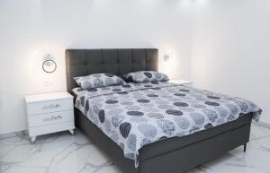 a bedroom with a bed with a black and white comforter at Apartman Viktor in Igalo