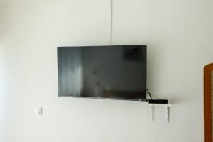 a flat screen tv hanging on a white wall at Beachfront Rooms Veli Kamik in Božava