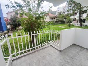 a white fence in front of a yard at Apartman Viktor in Igalo