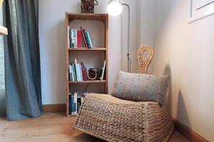 a room with a chair and a book shelf with books at La casica de Sabi in Sabiñánigo