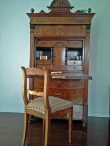 un armario de madera con una silla en una habitación en Deluxe Apartment, en Überlingen