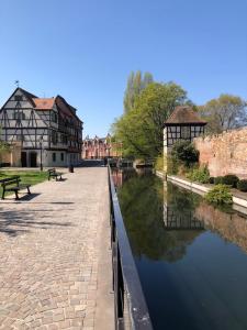 a canal in front of a building next to a river at Colombages de la Lauch in Colmar