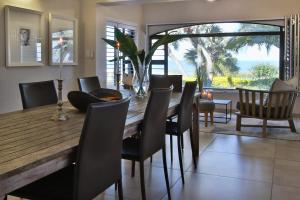 a dining room with a wooden table and chairs at Shorebreak in Southbroom