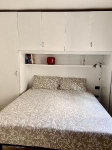 un lit dans une chambre avec des armoires blanches dans l'établissement La Boheme, à Padoue