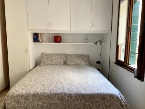 パドヴァにあるLa Bohemeの白いキャビネットが備わる小さな部屋のベッド1台分です。