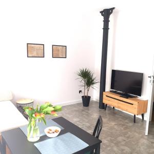 a living room with a table and a flat screen tv at Apartament z historią in Jelenia Góra