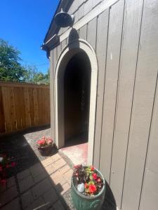 an archway in the side of a fence with two plants at NEW! Unique Coeur d’Alene Cottage. 1/2 Mi to Dtwn in Coeur d'Alene