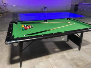 a green pool table with balls on top of it at הבית הלבן in Qiryat Shemona