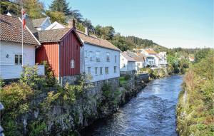 a river in a town with houses and buildings at Lovely Apartment In Hauge I Dalane With Kitchen in Sogndalsstrand