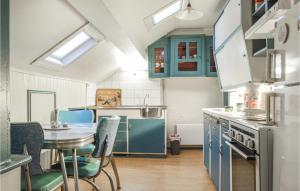 a kitchen with blue cabinets and a table with chairs at Lovely Apartment In Hauge I Dalane With Kitchen in Sogndalsstrand