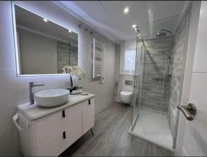 a white bathroom with a sink and a shower at Àtic Solé in Les Cases d'Alcanar