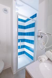 a bathroom with a shower with blue and white stripes at Apparthotel Le Hüb TOULON in Toulon