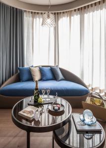 a living room with a blue couch and two tables at InterContinental Beijing Sanlitun, an IHG Hotel in Beijing