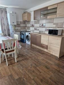 a kitchen with wooden cabinets and a table and a dining room at Splendid Aparthotel in Năvodari