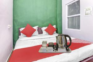 a bed with a tray with a tea kettle on it at OYO Sun Shine Hotel Laxmi Nagar in New Delhi
