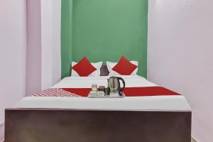 a bedroom with a bed with red pillows at OYO Sun Shine Hotel Laxmi Nagar in New Delhi