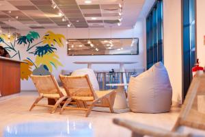 una habitación con sillas, una mesa y una pared con palmeras en Apparthotel Le Hüb TOULON en Toulon