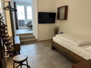 Schlafzimmer mit einem Bett, einem TV und einem Stuhl in der Unterkunft Sporthotel Igls in Innsbruck