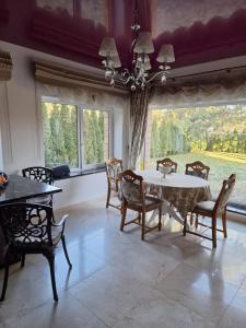 comedor con mesa, sillas y ventanas en Druskininkai Algida, en Druskininkai