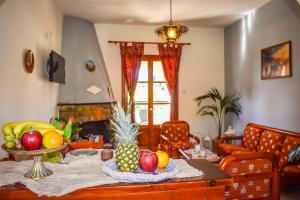 Koukias Village في ترولو: غرفة معيشة مع طاولة عليها فاكهة