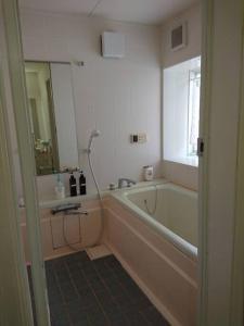 a bathroom with a bath tub and a sink at Urban Residence Ikebukuro East in Tokyo