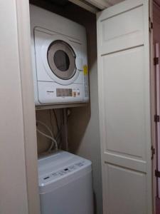 a laundry room with a washing machine and a microwave at Urban Residence Ikebukuro East in Tokyo