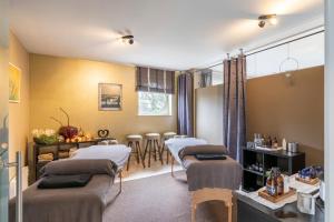 a therapy room with four beds and a table at Maas&Mechelen B&B Massage & Wellness in Maasmechelen