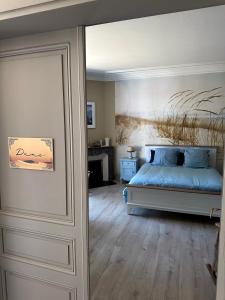 a bedroom with a bed with a painting on the wall at La Maison Florence in Mont-de-Marsan