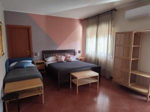 ein Schlafzimmer mit 2 Betten und einem Bücherregal in der Unterkunft B&B CasaBuddace in Messina